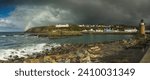 Pano of Port Patrick harbour with nice light dark storm clouds blue sky and a rainbow.