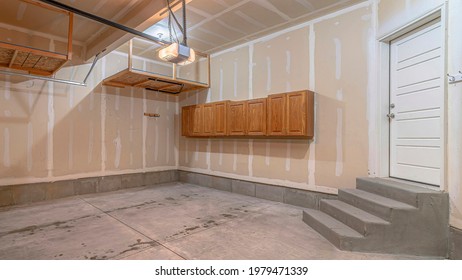 Pano Residential Garage Interior Under Construction With Unfinished Wall And Floor. Steps And Door Going Inside The House Can Also Be Sen In The Room.