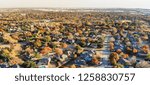 Panorama aerial view residential neighborhood with sprawl subdivision in background. Flyover single-family houses with colorful autumn leaves in Flower Mound, Texas, USA, blue sky