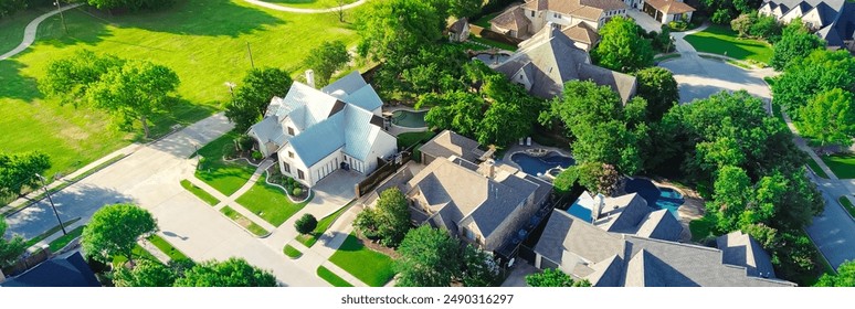 Panorama aerial view suburban park lush green trees, concrete walking path in wealthy residential neighborhood large mansion houses, swimming pool, concrete roof tile, Dallas Fort Worth metroplex. USA - Powered by Shutterstock