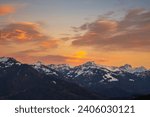 panorama with afterglow, alpine landscape with alp, snow on meadow, tree, forest with the mountains from Bregenz forest in background, colored clouds