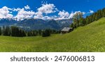 panorama with alpine houses and flowered meadows on the roadside, wooden cabin next to the path, hiking, we come across old alpine three stage farming huts, hiking in the mountains from Vorarlberg