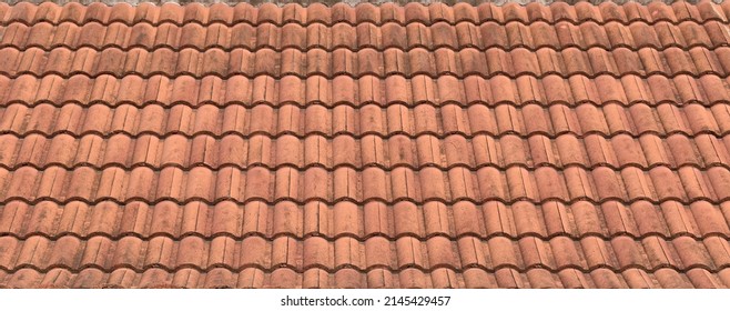 panorama of antique roof clay tiles of thai temple or ancient house, closeup repetitive wave pattern of orange roof clay tiles, Asian traditional exterior architecture detail for banner background