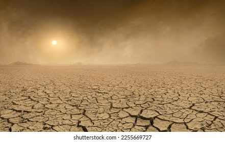 Panorama of arid barren land with cracked soil and sun barely visible through the approaching sand storm. Ecology problems concept