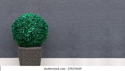 Panorama Of An Artificial Boxwood Ball In A Brown, Braided Planter As A Decoration In Front Of A Gray And White Wall 