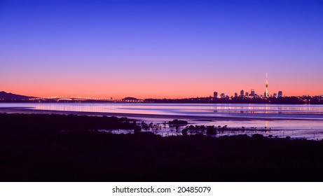 A Panorama Of Auckland City, Harbour Bridge And Rangitoto Island At Sunrise