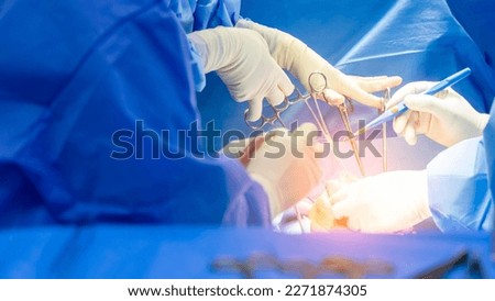Panorama banner inside operating room.Doctor and team of nurse doing surgery inside a theatre in hospital.Orthopedic spine surgery with medical instrument.Surgeon in blue sterile uniform in close up.