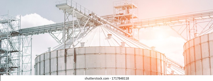 Panorama Banner Modern Crop Processing Plant Facility For Storage, Drying And Processing Of Raw Harvest Product: Grain, Corn, Wheat. Agriculture Business Silos Building Exterior. Grain Warehouse Tower