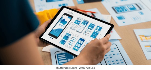 Panorama banner of startup UX developer or company employee design user interface or UI prototype for mobile application or website software with software display on tablet screen in office. Synergic