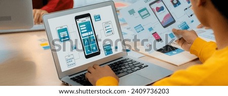 Panorama banner of startup UX developer or company employee design user interface or UI prototype for mobile application or website software with software display on laptop monitor in office. Synergic