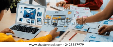 Panorama banner of startup UX developer or company employee design user interface or UI prototype for mobile application or website software with software display on laptop monitor in office. Synergic