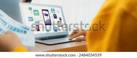 Panorama banner of startup UX developer or company employee design user interface or UI prototype for mobile application or website software with software display on laptop monitor in office. Synergic