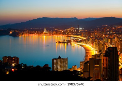 Panorama of the beach in Benidorm and night lights of the city at sunset (Spanish coast)