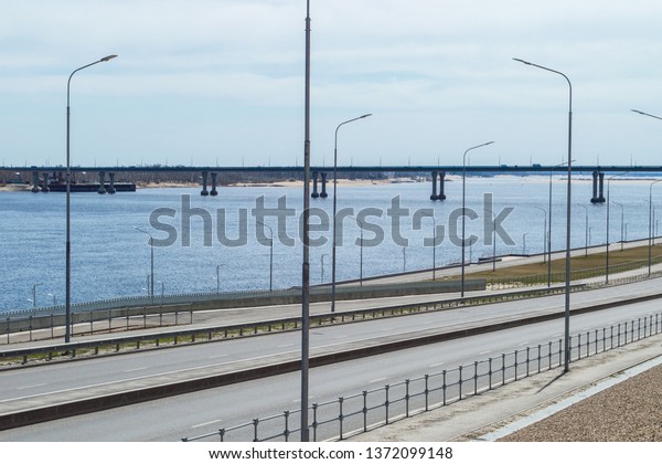 Panorama of big river, riverside with roadway and\
bridge across the\
river