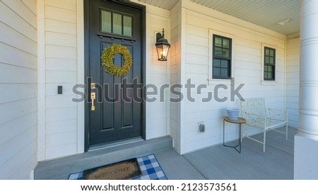 Panorama Black front door with wreath, window panel and doorbell camera