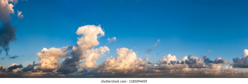 Panorama Of Blue Sky With Dark Clouds On The Horizon. Dramatic Atmosphere Preceding The Storm. Cumulus Formation. Threatening Sky. High Resolution Panoramic Sky.