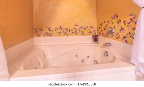 Panorama Built In White Jacuzzi Tub Inside A Bathroom With Flower Designs On The Wall