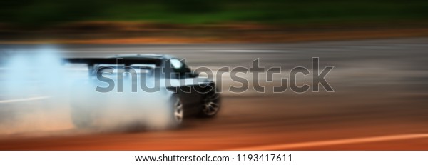 Panorama car\
drifting, Blurred of image diffusion race drift car with lots of\
smoke from burning tires on speed\
track
