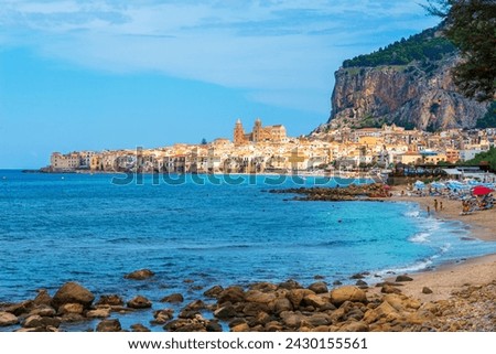 Panorama of Cefalu coastal town and the sandy beach on the coast of Sicilian coast in Italy in the summertime. 