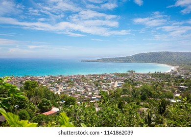 Panorama of the city of Baracoa, encompassing lush green vegetation and stunning ocean shoreline views, Cuba.