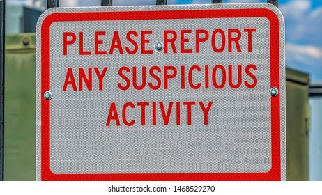 Panorama Close Up Of A Sign That Reads Please Report Any Suspicious Activity