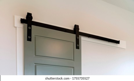 Panorama Closed Sliding Gray Panel Door With Black Handle Against White Wall Of Home