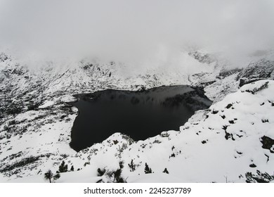 Panorama in the clouds at the Black Caterpillar Pond . Polish Tatra Mountains in winter aura with lots of snow.