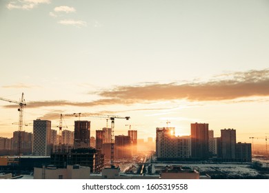 Panorama of construction at sunset. Construction of a residential complex with cranes. 