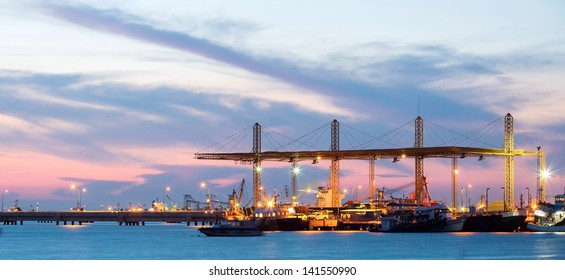 Panorama of Container stacks and crane in shipyard at dusk for cargo Goods and Logistic background