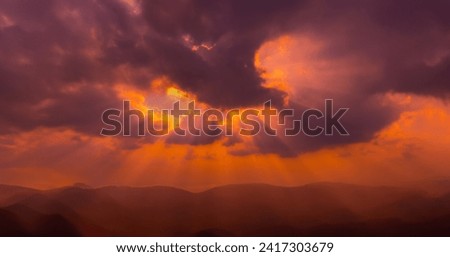 Panorama Dark cloud sunset over Dark mountain.Colorful sunrise with Clouds over hill.Sun hiding behind a cloud on the day sky.Sunray Clouds sunset.Warm tone environment earth.