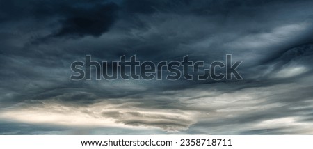 Panorama of dark dramatic sky with heavy cloud and storm formation in moody weather on overcast day