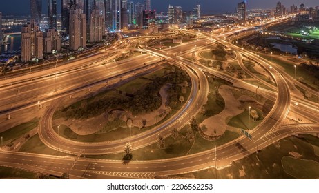 Panorama of Dubai Marina highway intersection spaghetti junction night to day transition. Illuminated tallest skyscrapers and golf course on a background. Aerial top view from JLT district - Shutterstock ID 2206562253