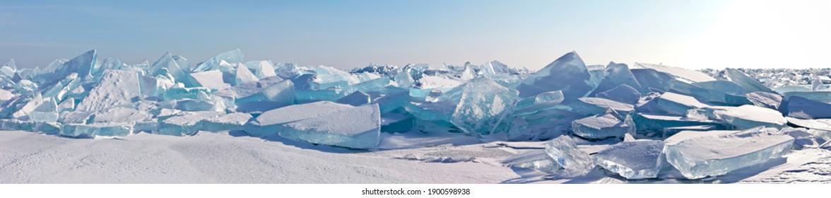 A panorama the edge hummock field and beautiful huge blocks transparent blue ice the frozen Lake Baikal sunny frosty day  Cool natural background  Unusual winter landscape
