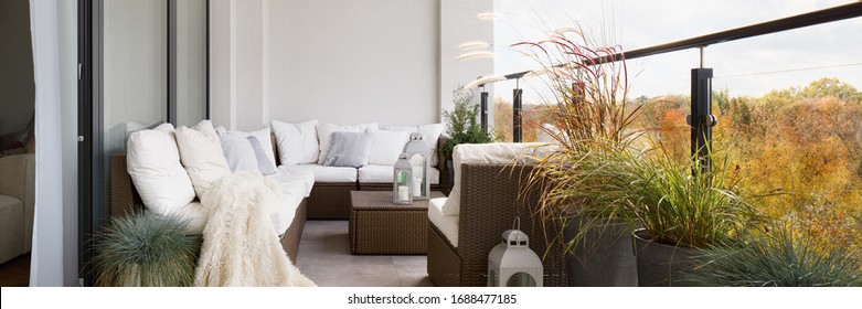 Panorama Of Elegant Decorated Balcony With Rattan Outdoor Furniture, Bright Pillows And Plants