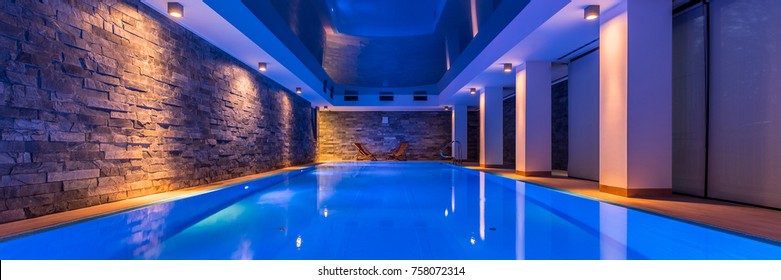 Panorama Of Elegant Swimming Pool With Decorative Led Lights And Brick Wall