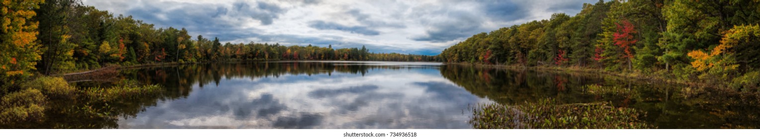 Panorama Fall Scene With Colorful Leaf Reflections On Lake Mcgrath. Wisconsin.