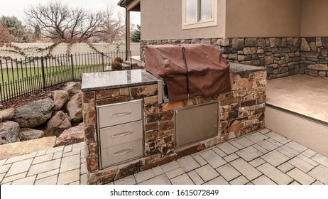 Panorama frame Covered stone outdoor kitchen on a paved patio