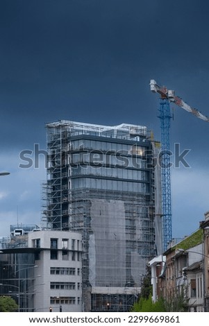 Panorama of a giant Construction site of a office building complex of skyscraper tower high rises, with scaffholdings, concrete and cement Facades as well as cranes, in a real estate development area.