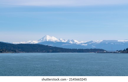 Panorama of glacier- and snow-capped Mount Baker of Washington state, also known as Koma Kulshan, with the Twin Sisters Range in the background and part of Anacortes Harbor to the right.