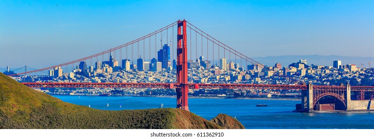 Panorama of the Golden Gate bridge in clear blue sky with green grass as foreground and San Francisco skyline in the background - Powered by Shutterstock