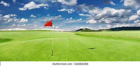 Panorama of golf course with red flag in a hole