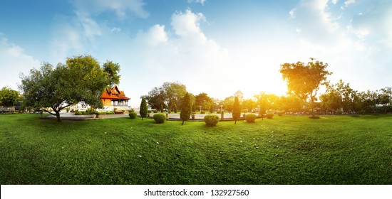 Панорама зеленого сада с буддийской зданием и луг с травой рано утром
