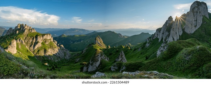 
Panorama of green meadow with rocks and rocky mountains in romanian mountains in muntii ciucas with setting sun - Powered by Shutterstock