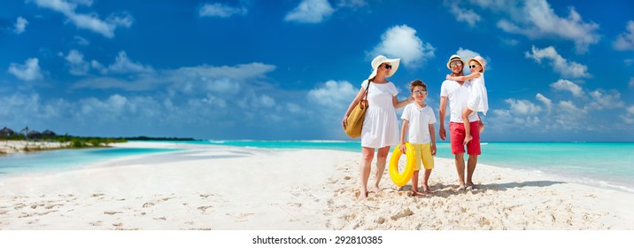 พาโนรามาของครอบครัวที่สวยงามมีความสุขกับเด็กเดินด้วยกันบนชายหาดเขตร้อนในช่วงวันหยุดฤดูร้อน