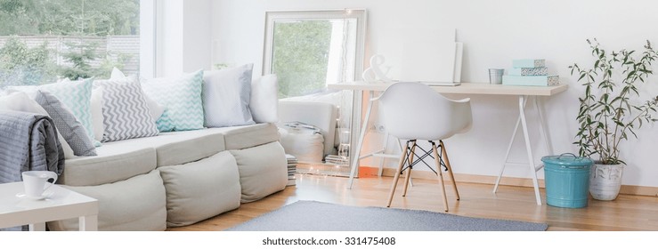 Panorama of interior with large sofa and simple study area