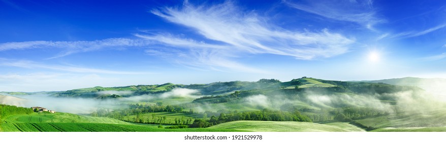 Panorama, Italian beautiful landscape, foggy rolling fields of Tuscany in light of the rising sun