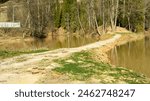 Panorama of the lake and green forest with fir trees in the park in summer in spring. Blue sky. with reflection in water. Park "Red Key" in Russia. Bashkiria. People Walking in the Park