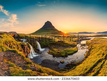 Panorama landscape of sunrise over volcanic Kirkjufell mountain with Kirkjufellsfoss waterfall in summer at Snaefellsnes peninsula, Iceland