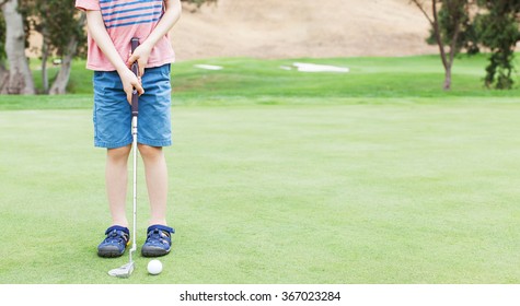 panorama of little boy learning to play golf