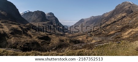 Panorama looking west through Glen Coe with the Three Sisters on the left, Aonach Eagach ridge on the right and winding A82 road viewed from the old military road. Stock photo © 